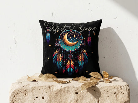 Coussin noir Essences Agape avec motif attrape-rêves, lune, étoiles et plumes colorées. Texte "Perfect Dreams".