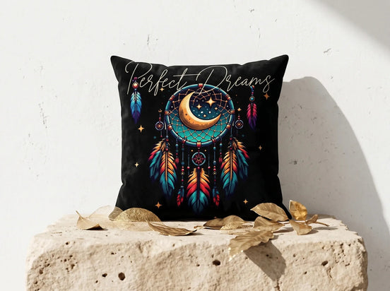 Coussin noir Essences Agape avec motif attrape-rêves, lune, étoiles et plumes colorées. Texte "Perfect Dreams".