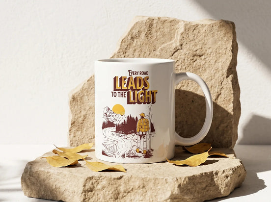 Essences Agape - Mug blanc en céramique avec illustration d'un randonneur sur un chemin, texte "Every road leads to the light".