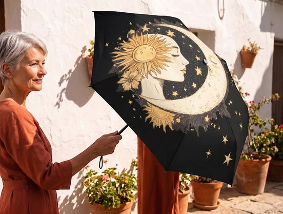 Essences Agape parapluie pliant noir avec motif soleil, lune et étoiles dorées, idéal pour un style spirituel.