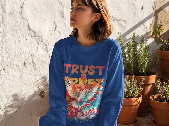 Sweatshirt bleu roi Essences Agape à manches longues avec un imprimé "Trust In God" et une colombe devant une croix.