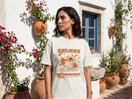 Essences Agape t-shirt blanc cassé avec inscription "Believe in Yourself" et bouquet floral, coupe unisexe.