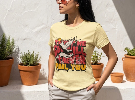 Tee shirt jaune pâle oversize Essences Agape avec un imprimé graphique religieux sur le devant : une colombe et des mains sous le texte "Trust me God will never fail you".