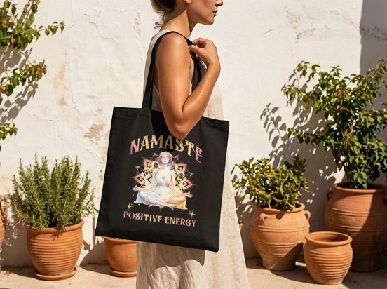 Essences Agape tote bag noir en coton avec illustration femme méditant, symboles spirituels et texte "Namaste Positive Energy".