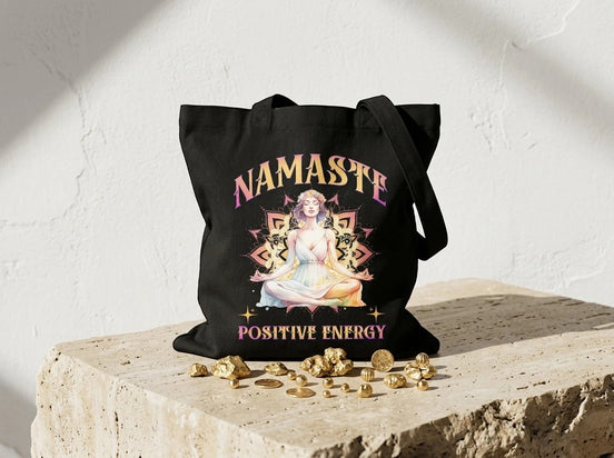 Sac fourre-tout noir Essences Agape avec illustration d'une femme en méditation, texte "Namaste Positive Energy", idéal yoga et spiritualité.
